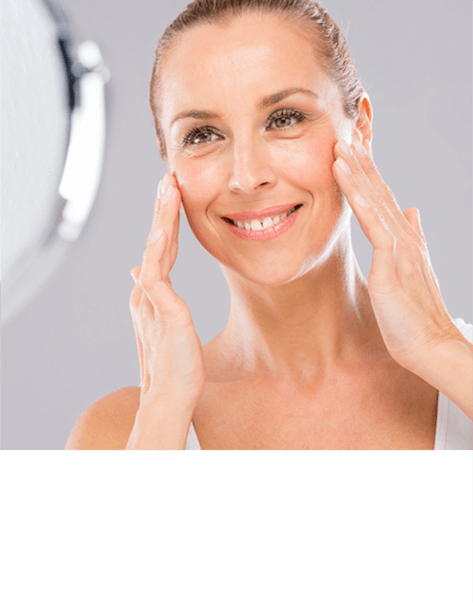 Woman applying face cream to her cheeks.